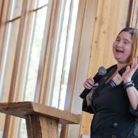 Natalie Trent standing at podium, talking to group
